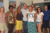 Miramar Theatre staff are presented with a new display plaque on Kirsty MacColl by participants on the 2017 Cycle Cuba Challenge