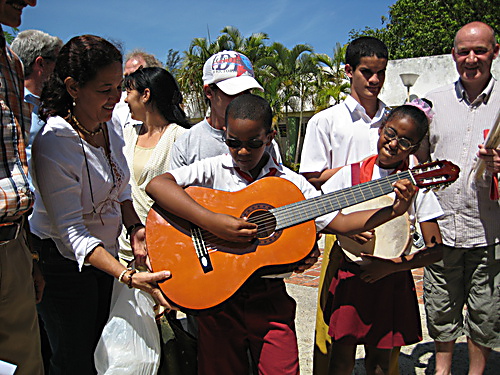 Handing over a guitar to one of the students